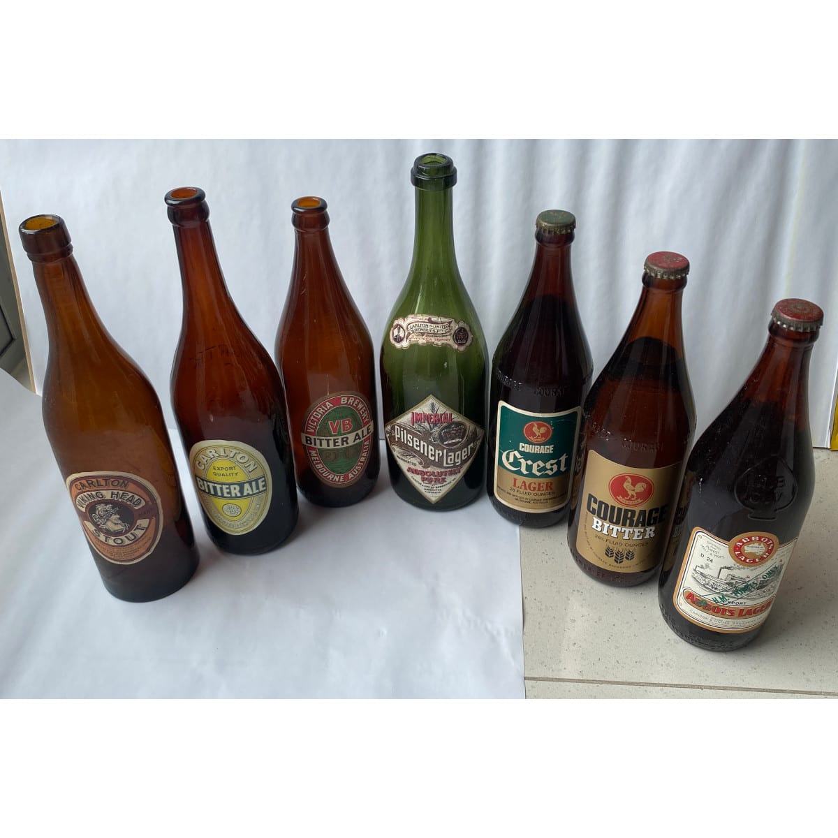 7 labelled beer bottles: 5 x CUB, 2 x Courage Brewery. Abbots Lager HM Forces Imperial Pilsener Lager Viking Head Stout and more. (Victoria)