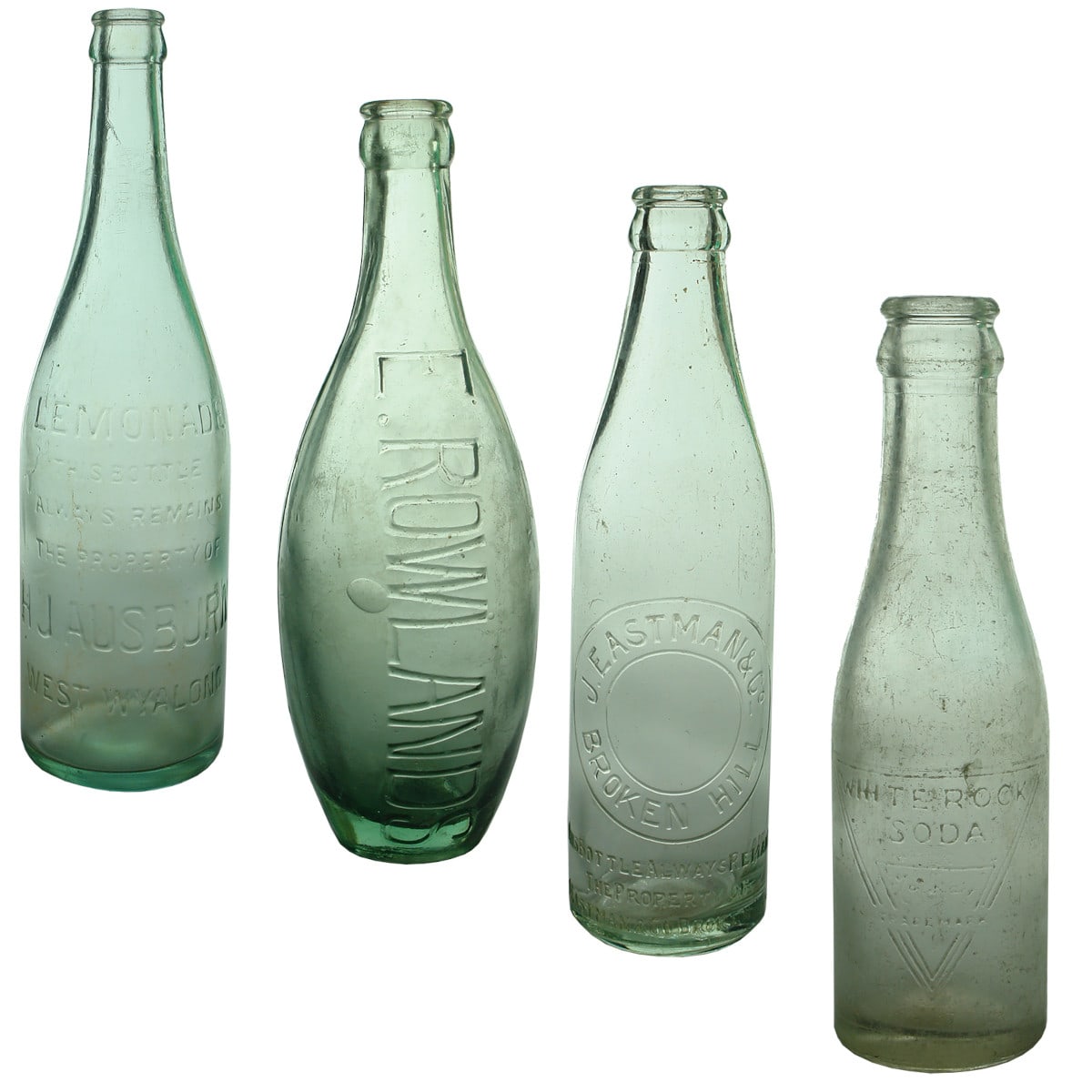 4 Crown Seals. H. J. Ausburn, West Wyalong. 26 oz; E. Rowlands 10 oz Skittle; J. Eastman & Co., Broken Hill. Odd Elongated Shape. Aqua. 10 oz; White Rock Soda, Mackay & Co, Perth. Clear. 4 oz.