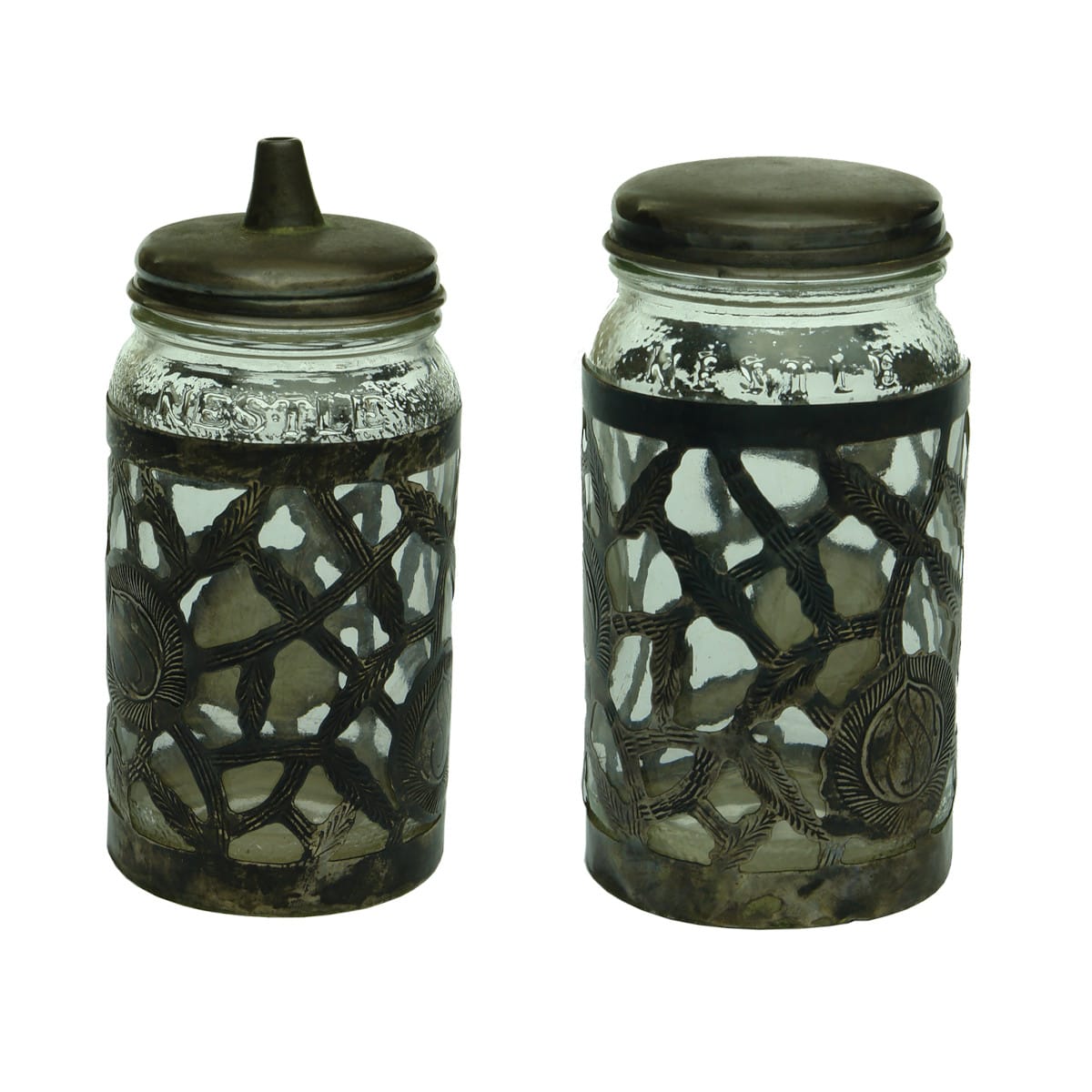 Pair of Jars. Both embossed Nestle twice around shoulder. But both have specially fitted lids, one with a pourer and silver(?) lattice like decoration put around them.