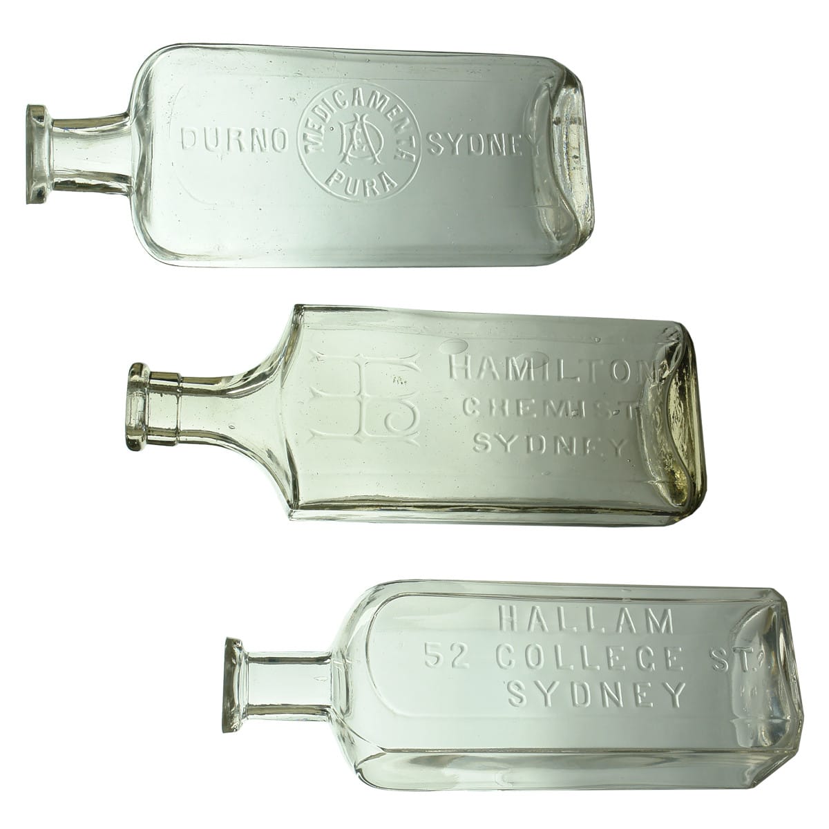 3 Chemists. Durno, Sydney. Medicamenta Pura. M base mark. 10 oz. 174 mm; Hamilton, Sydney. Monogram. Fancy shape. Clear. Tool finished top. 12 oz. 203 mm; Hallam, 52 College St., Sydney. Clear. 12 oz. 182 mm. (New South Wales)