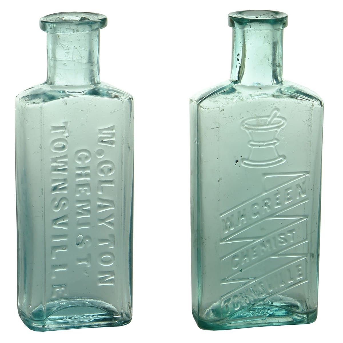 2 Chemists. W. Clayton, Townsville. Maws base mark. Aqua. 1 oz. 94 mm; W. H. Green, Townsville. Mortar & Pestle. Aqua. 1.5 oz. 107 mm. (Queensland)