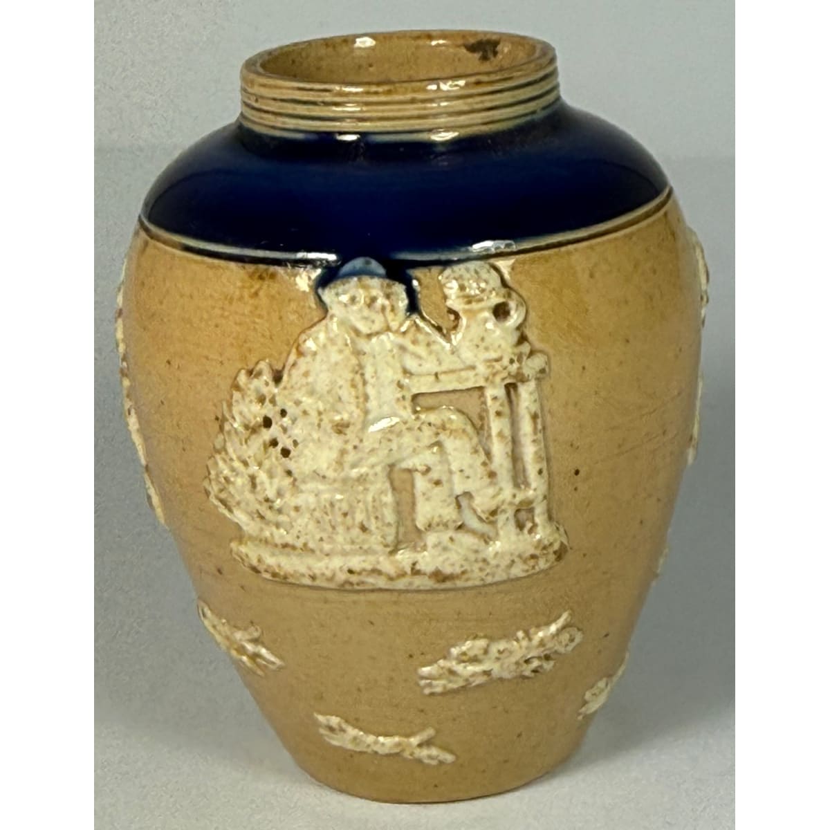 Miniature Doulton Lambeth Vase. Blue top. Applied white decoration of Men drinking or smoking and Dogs underneath.
