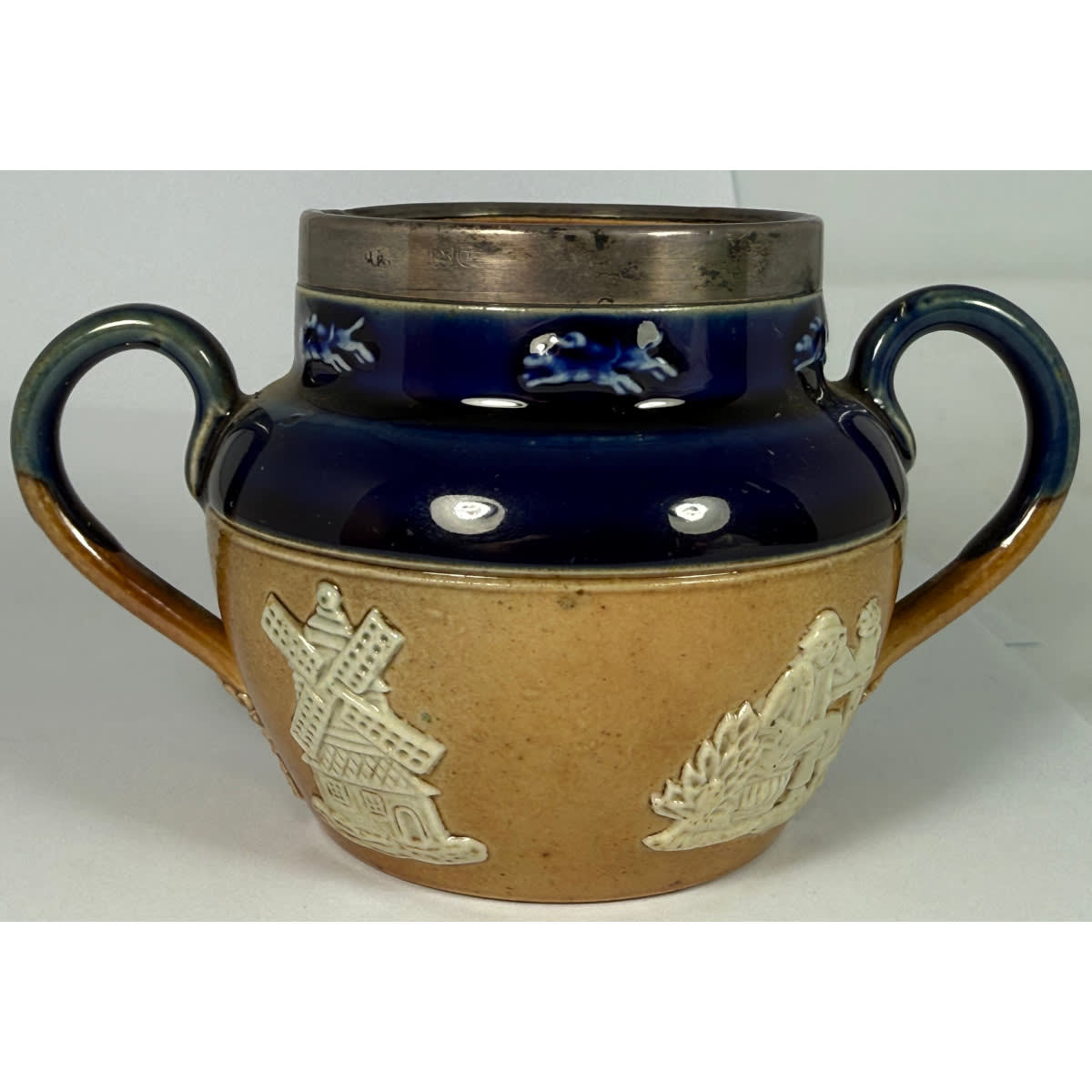 Small Royal Doulton double handled pot or bowl. Blue top. Added silver rim. Applied white decoration.