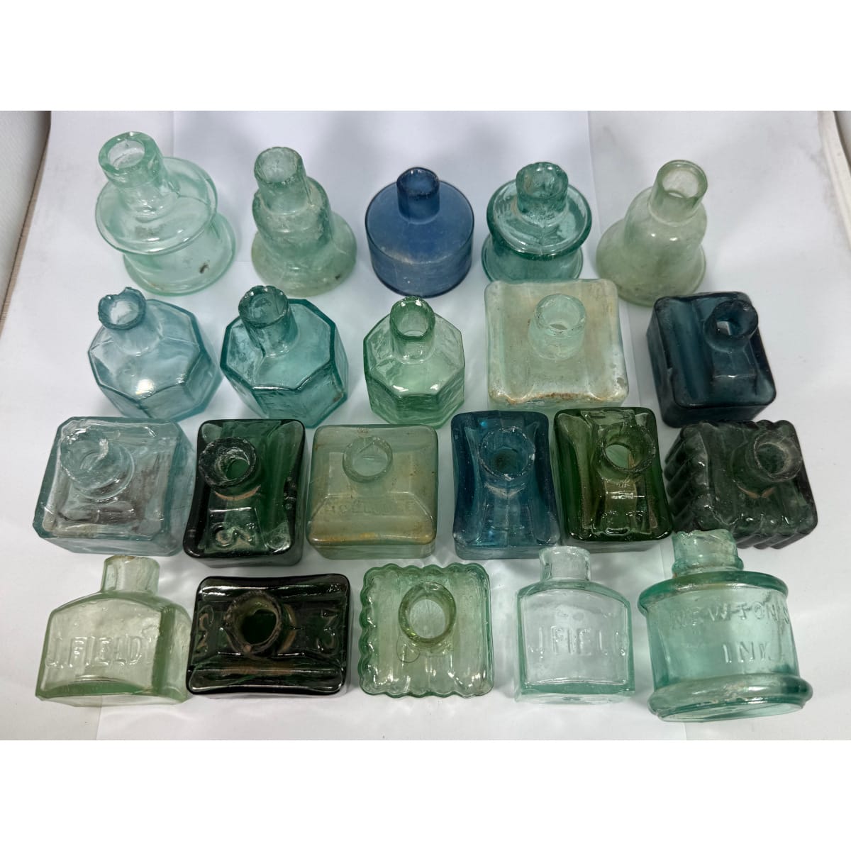21 Glass Inks. Boat shapes; Octagonal; Bell; Cotton Reel and others. Mostly aqua with some nice blues and greens.