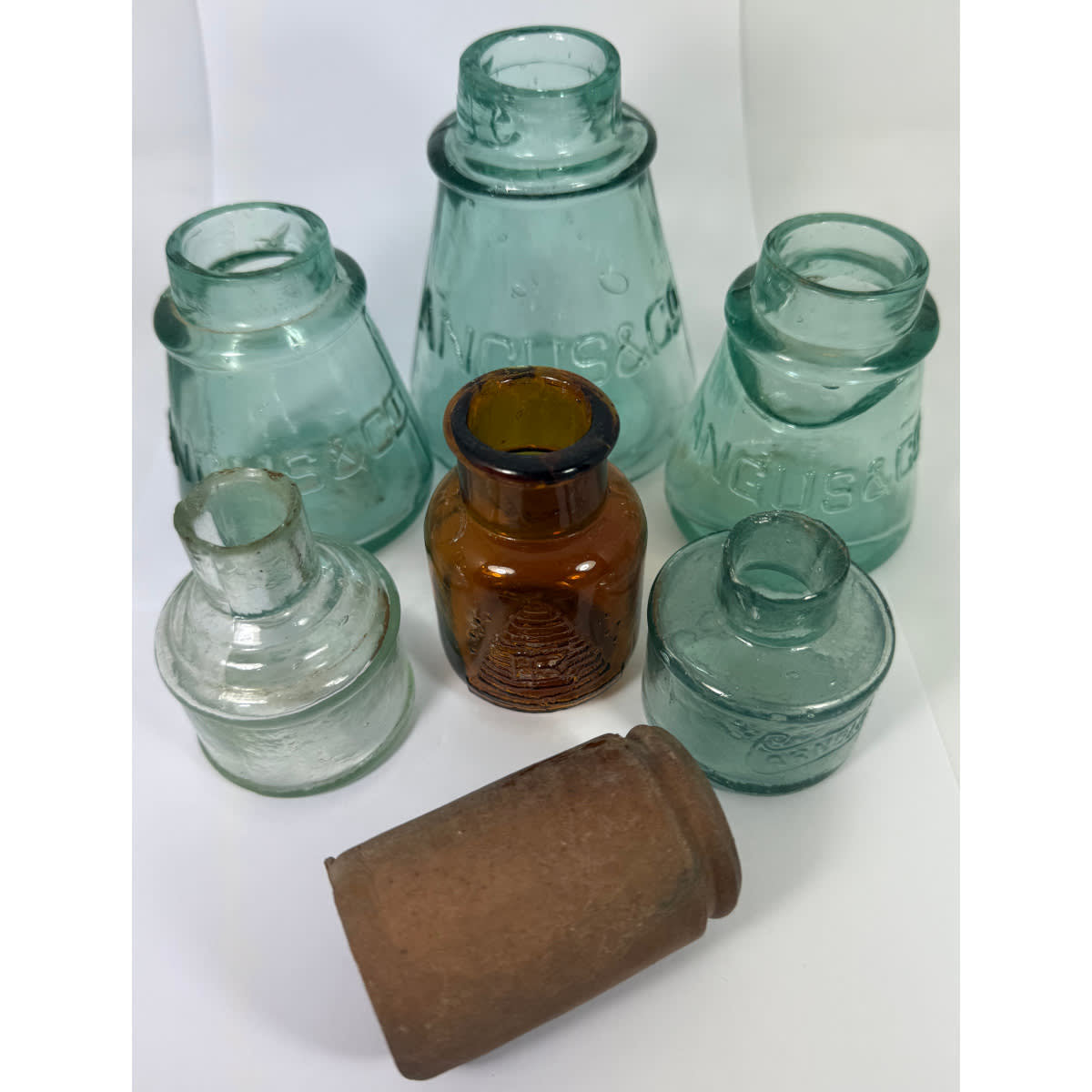 7 wider mouth jars: Angus & Co Clag; Elliott Bros Amber Beehive; Stoneware Ointment; Arnold's Ink and plain cotton reel ink.