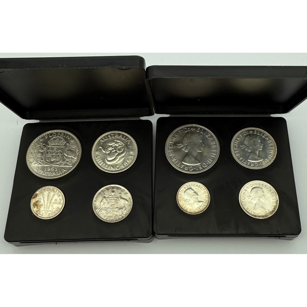 2 sets 1963 Proof Australian Silver Coins. One set showing obverse and one showing reverse. 50% silver. In original black plastic cases.