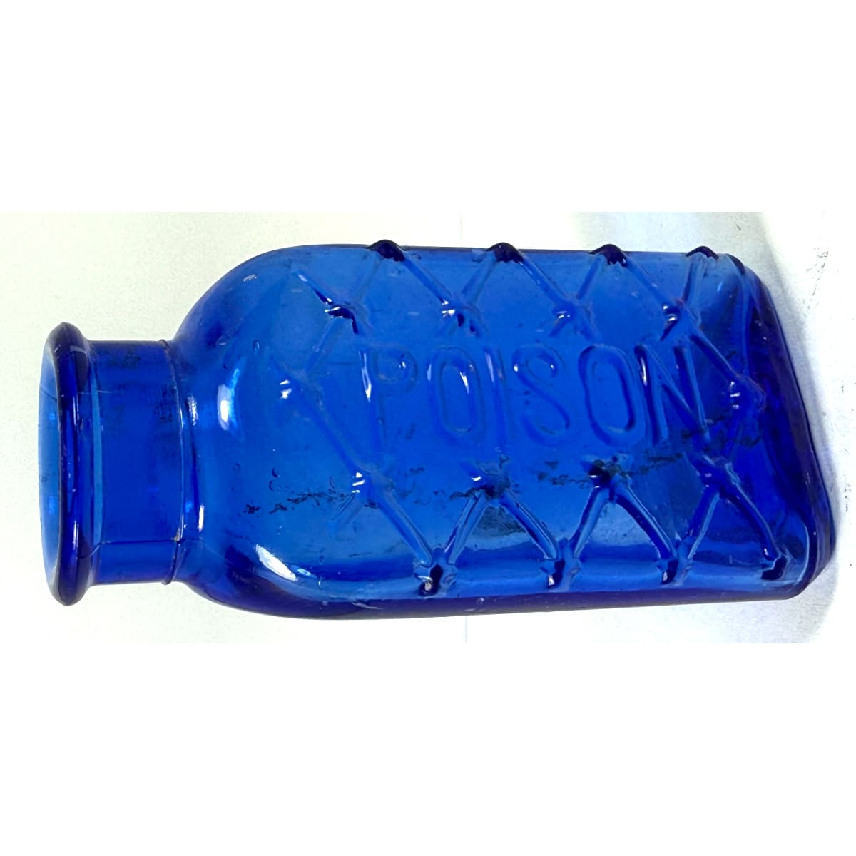 Poison. Triangular with Poison embossed down front and lattice pattern around it. 040 to base.