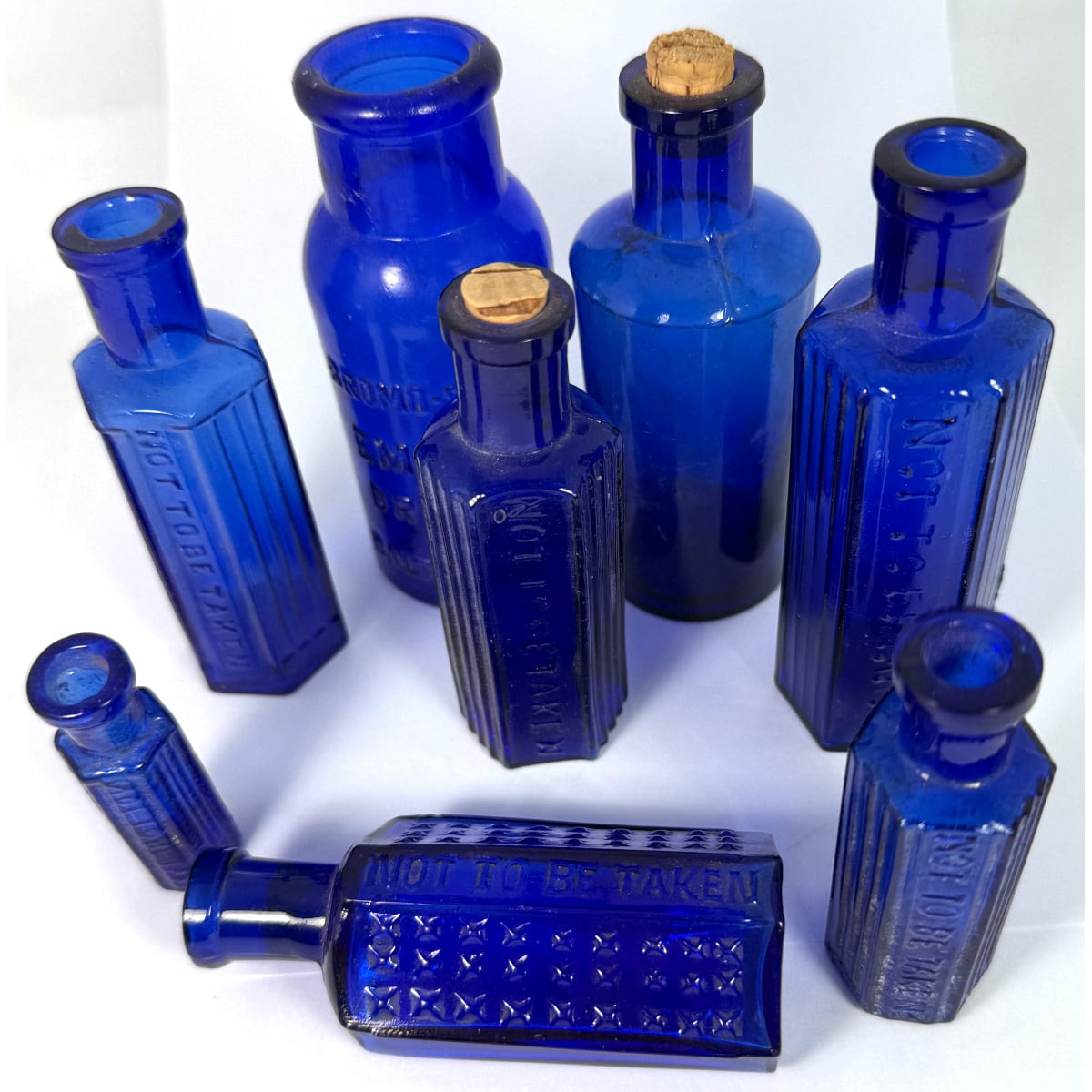 8 Cobalt Blue Bottles: 6 x Not to be taken poisons; Bromo-Seltzer; Plain round three piece mould.