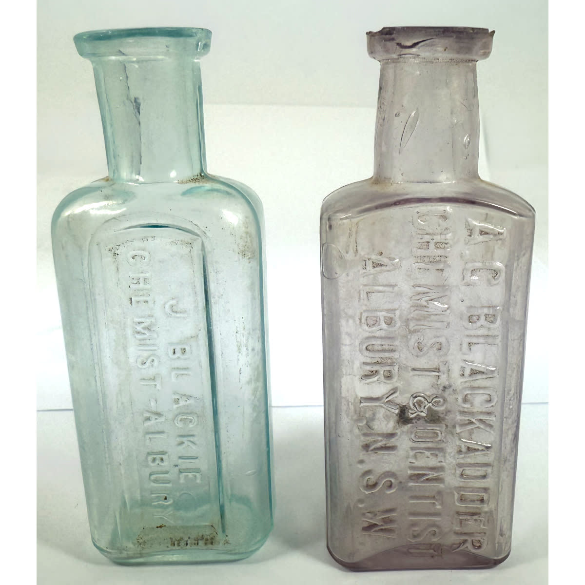 2 small Albury Chemist bottles: A. G. Blackadder, Chemist & Dentist; J. Blackie. Pale Amethyst & Aqua. Both about 90 mm. (New South Wales)
