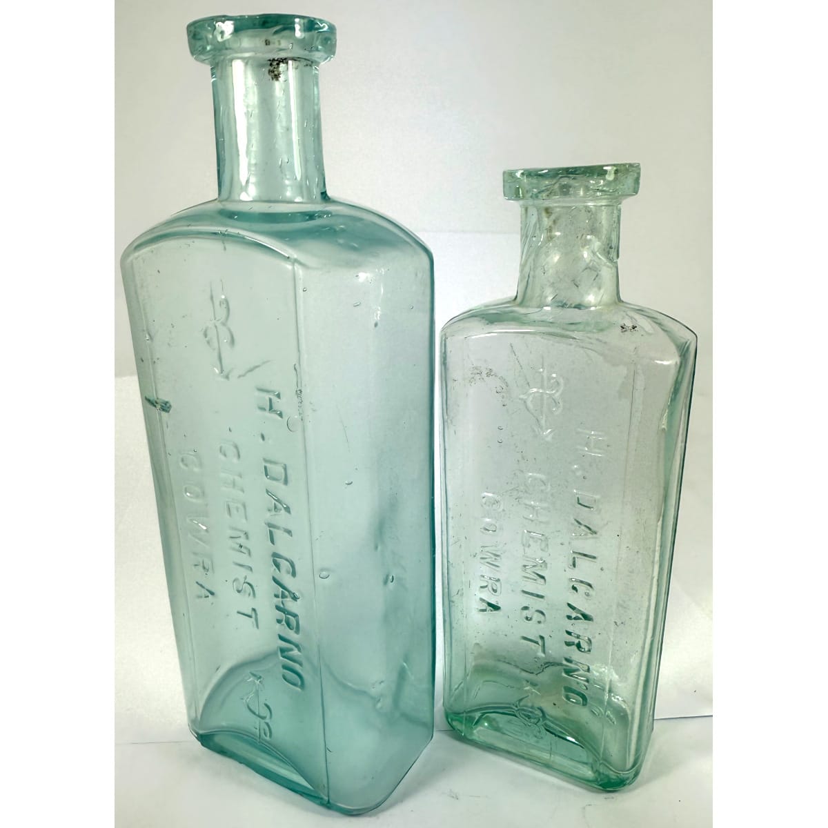 2 Cowra Chemists. Both H. Dalgarno with fancy arrows in the embossing. 8 oz (169 mm) and 4 oz (142 mm). (New South Wales)