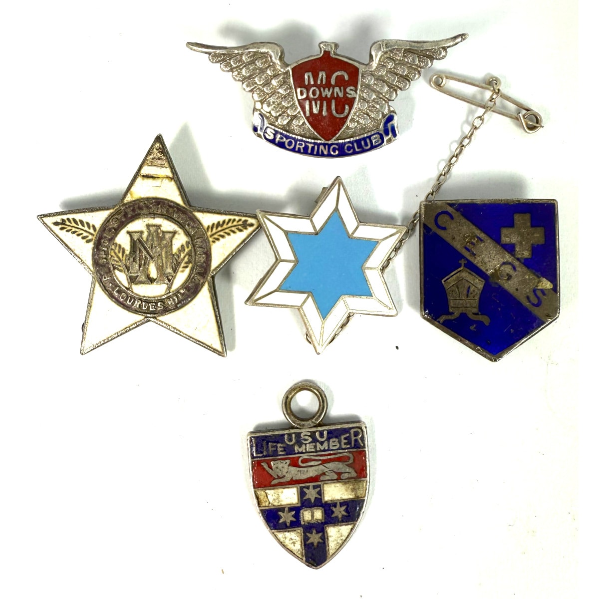 5 Badges. All marked Sterling Silver. School badges, Masonic Debutante 1969, USU Life Member; Downs MG Sporting Club. Total weight 27 grams.