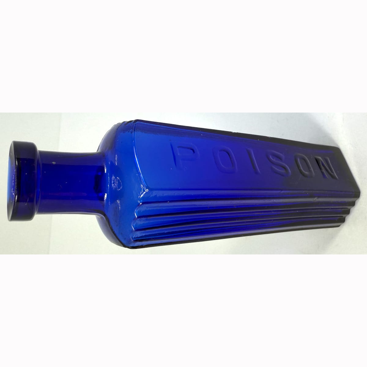 Poison. Hexagonal. Poison embossed on middle panel. Vertical ribs to two panels either side. Cobalt Blue. 2 oz. 114 mm.