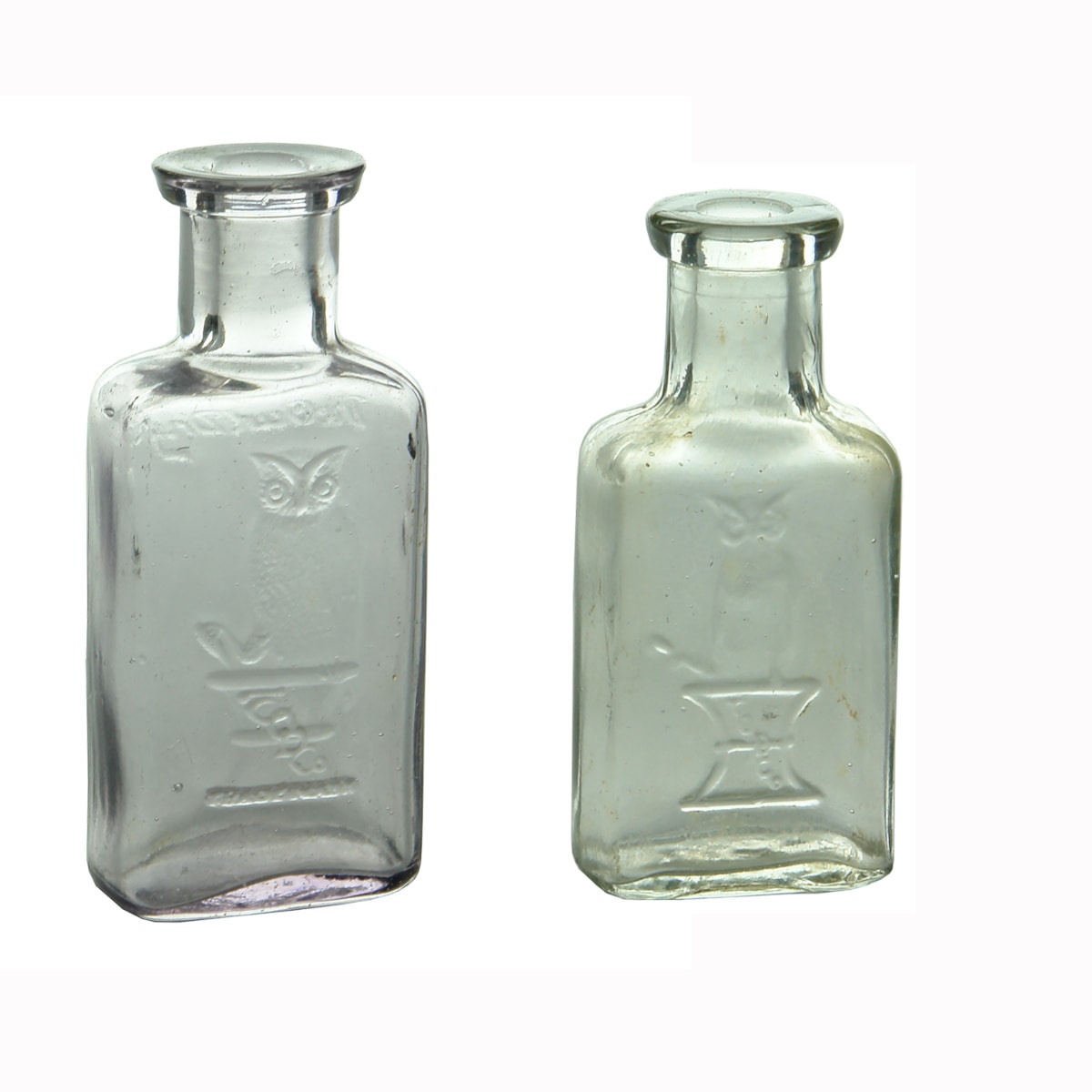 2 Medicines. The Owl Drug Co. One Wing. Pale Sun Coloured Amethyst. Rounded Oblong. 80 mm and The Owl Drug Co. Two Wing. Clear. Rounded Oblong. 63 mm. (USA)