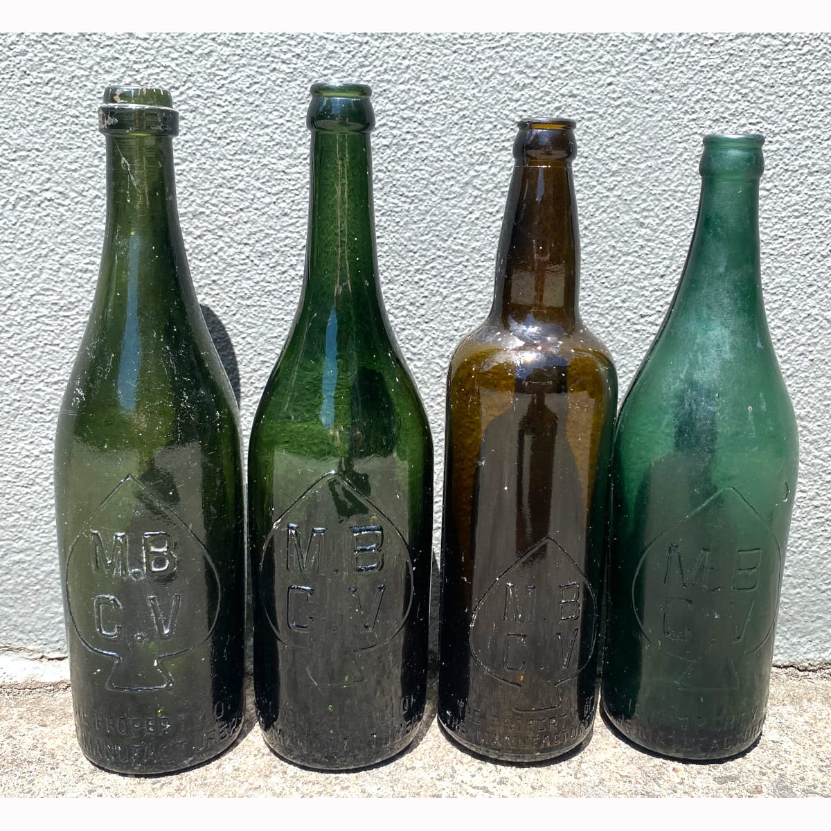 4 MBCV Beer Bottles: Crude Ring Seal with A base mark; Dark Green Crown Seal; Shouldered off amber crown seal; Bluey Green Crown Seal. Manufacturers Bottle Co of Victoria.