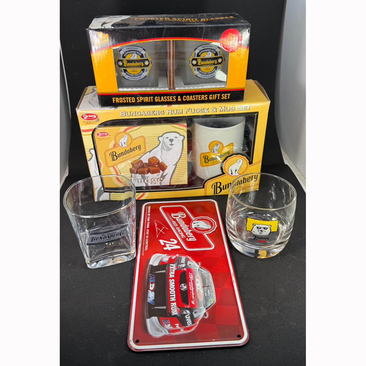 Bundaberg Rum Souvenir group: Mug & Fudge in original box; Frosted Spirit Glasses & Coasters in original box; "Number Plate" Red Racing; 2 other Glasses.