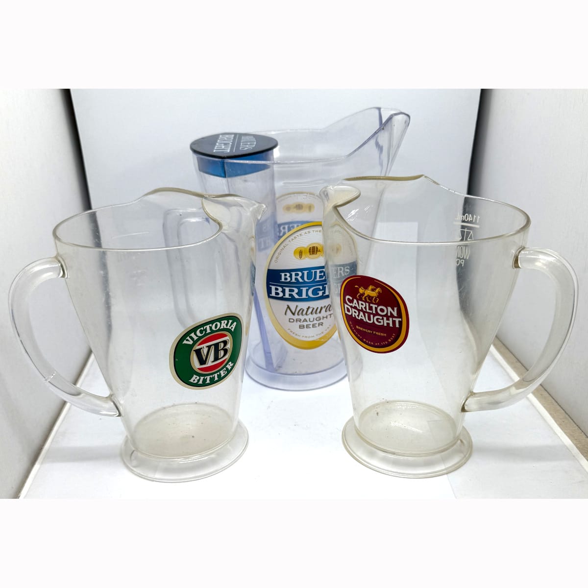 3 Advertising Plastic Beer Jugs: Breuers Bright (with ice holder at the back); Victoria Bitter & Carlton Draught.