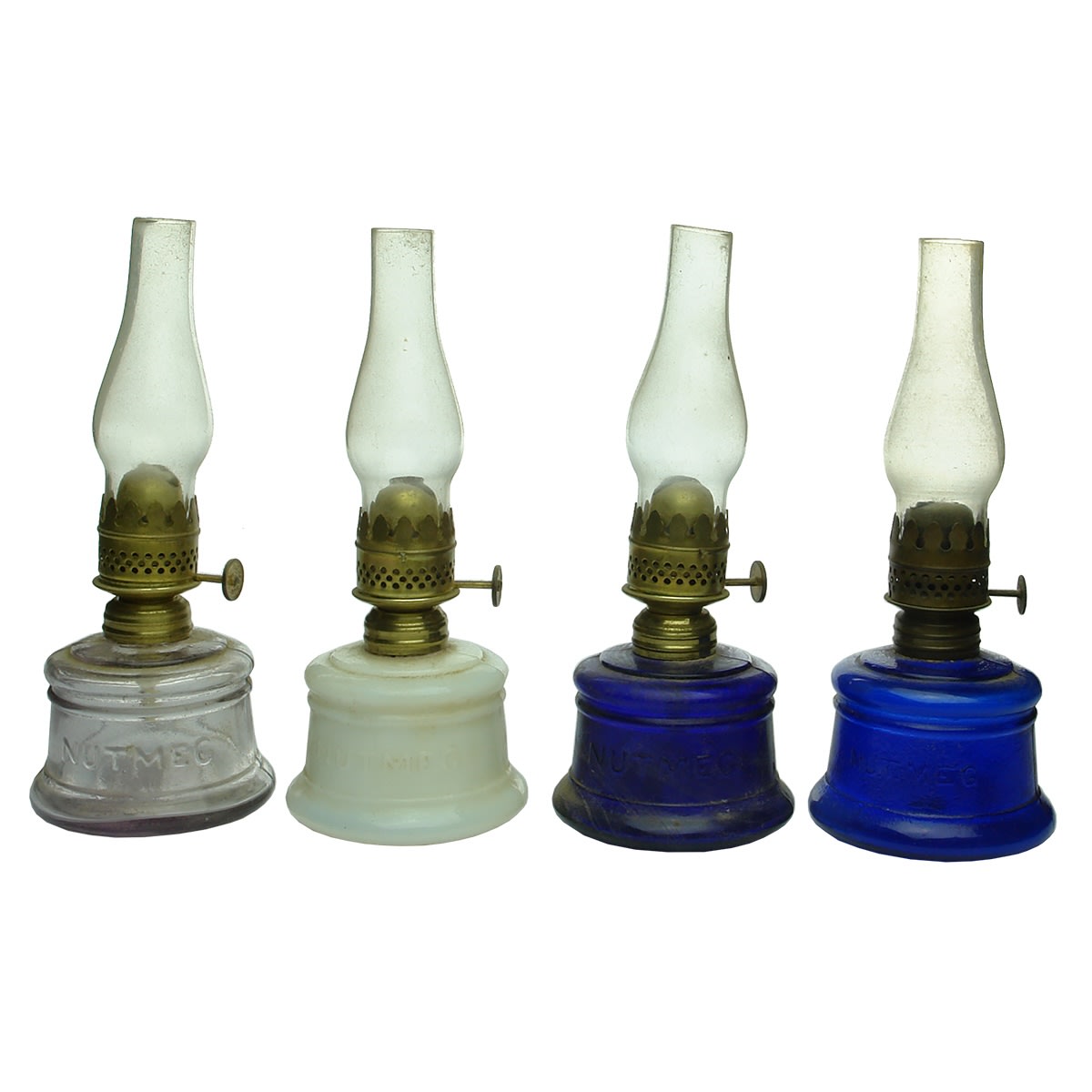 Lamps: All Nutmeg Lamps with brass burners and glass chimneys: 1. Amethyst. 2. Milk Glass. 3. Deep Cobalt Blue. 4. Lighter Cobalt Blue.