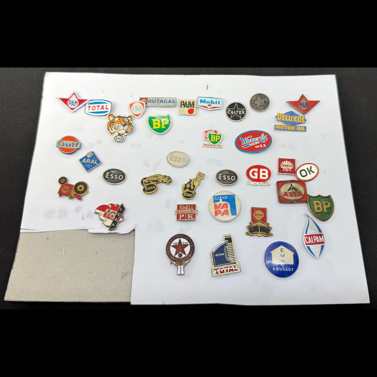 Collection of 30 odd Oil Company pins in a small frame. Esso, Total, Gulf, Shell, Caltex, BP, Texaco and more.