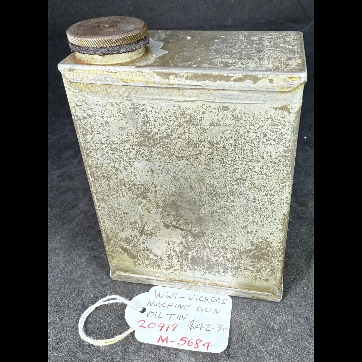 Plain tin. Brass screw cap with longtube and brush attached. Tag says WWI Vickers Machine Gun Oil Tin.