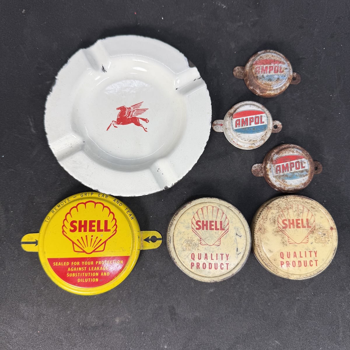 7 Items: Pegasus facing left enamel ashtray; Shell tab seal; 2 x Shell screw top lids; 3 x small Ampol tab seals.