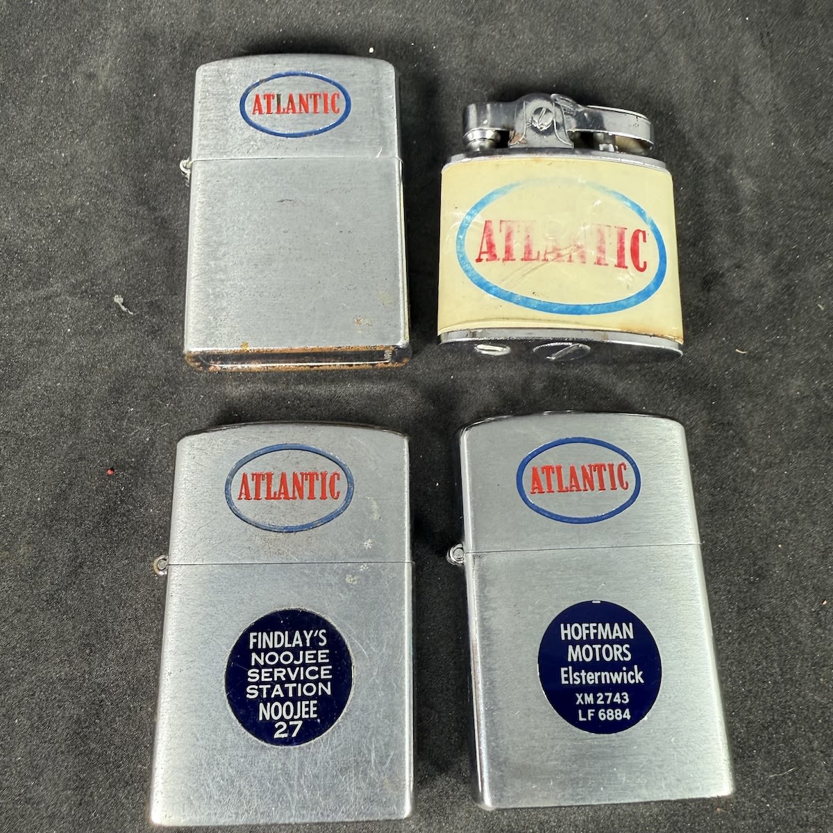 4 Atlantic promotional lighters: 3 silver types, 2 have stickers for Hoffman Motors Elsternwick & Findlay's Noojee Service Station. 4th one with mother of peal effect.