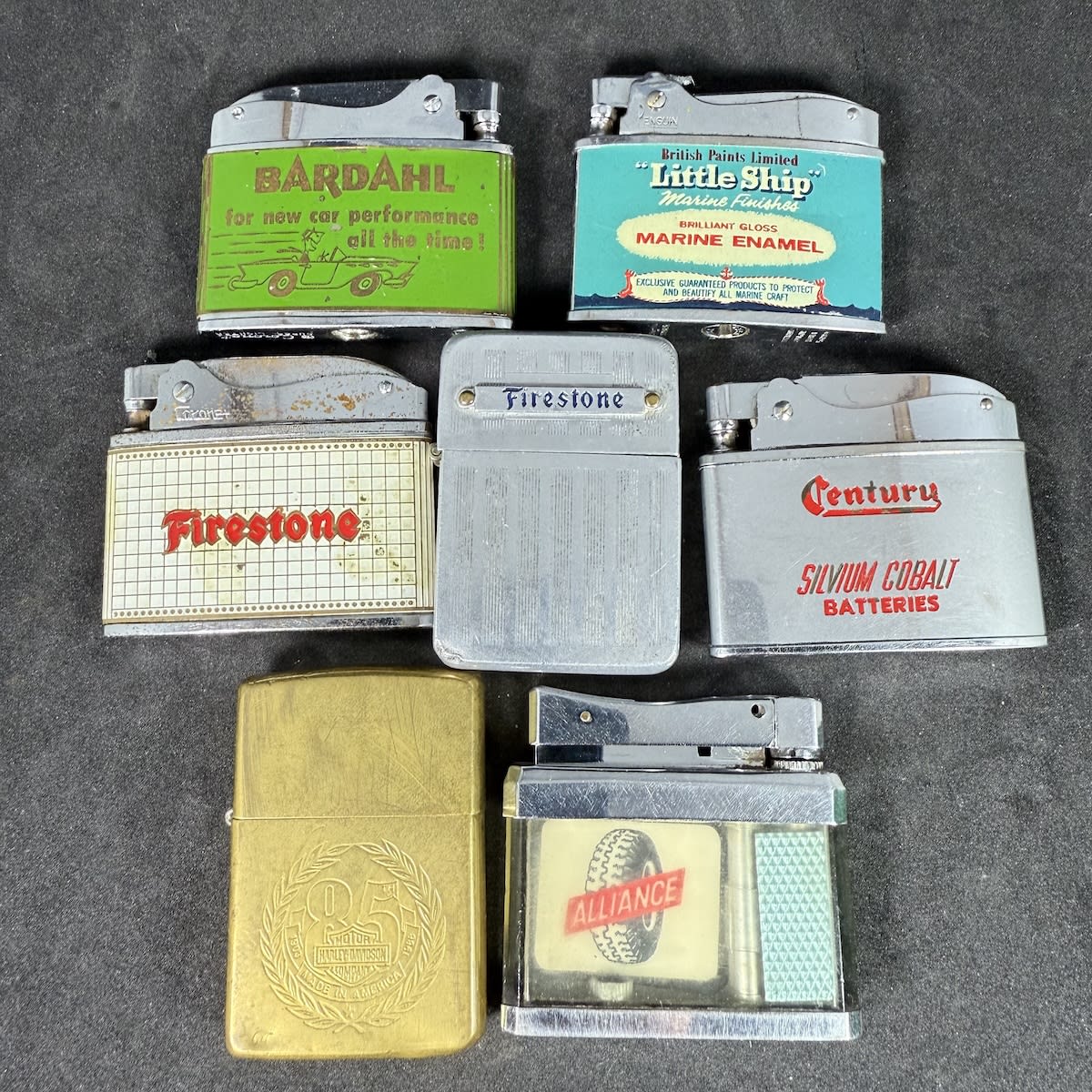 7 advertising lighters: Bardahl; British Paints - Gretel America's Cup; Century Batteries; 2 x Firestone; Alliance; Harley Davidson 85th Anniversary.