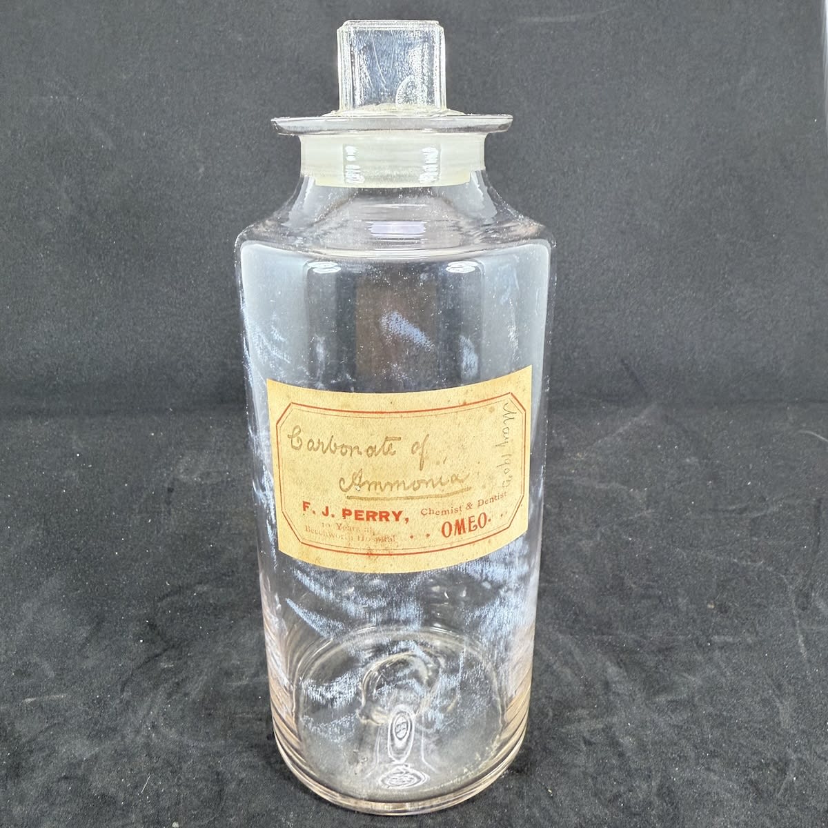 Chemist Jar. Plain pontil scarred, stoppered jar. Original label: F. J. Perry, Chemist & Dentist, Omeo. Carbonate of Ammonia. May 1903 in pencil. (Gippsland, Victoria)