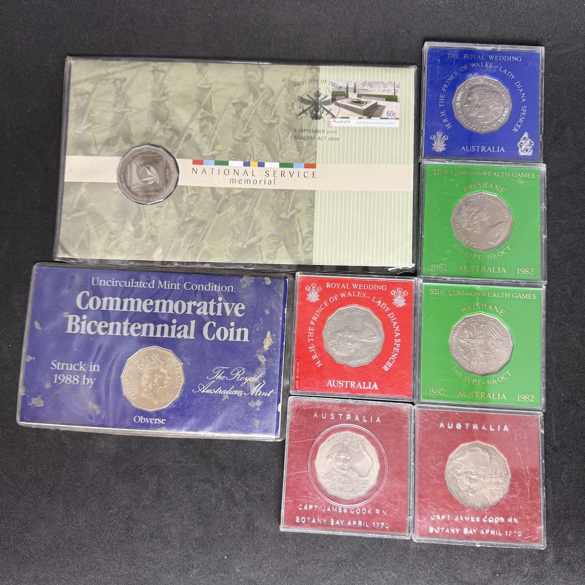 Numismatics. 8 Australian 50 cent coins in various commemorative packs. 2 x James Cook 2 x Royal Wedding 2 x Commonwealth Games Bicentennial & National Service.