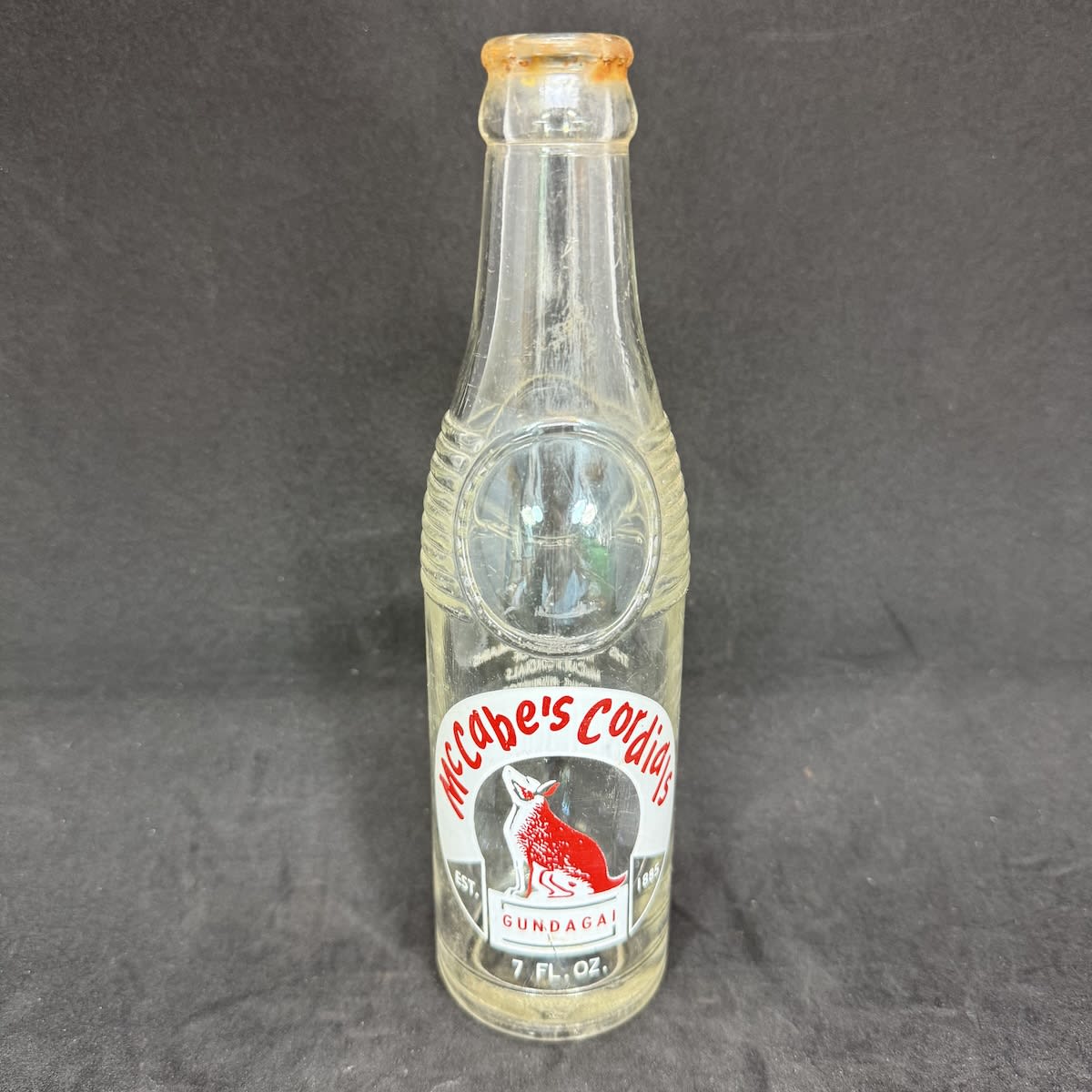 Ceramic Label Crown Seal. McCabe's Cordials, Gundagai. J. Jones Proprietor. Dog on Tuckerbox. Bullet shape. 7 oz. (New South Wales)