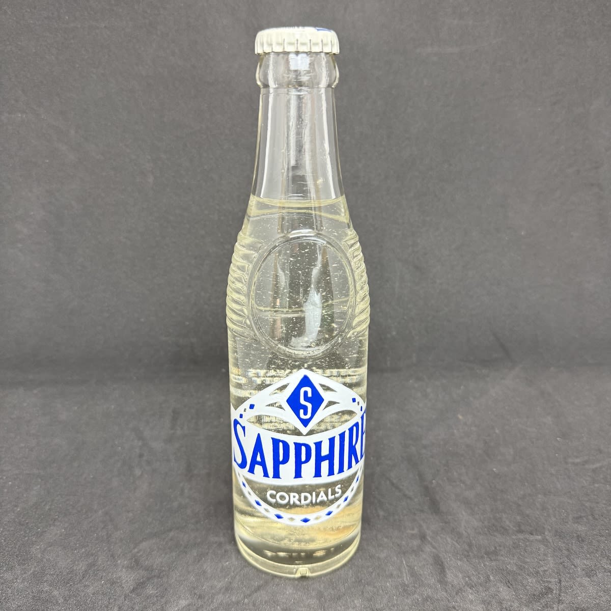 Ceramic Label Crown Seal. Sapphire Cordials, Bega. 7 oz. Sealed with original cap and contents. (New South Wales)