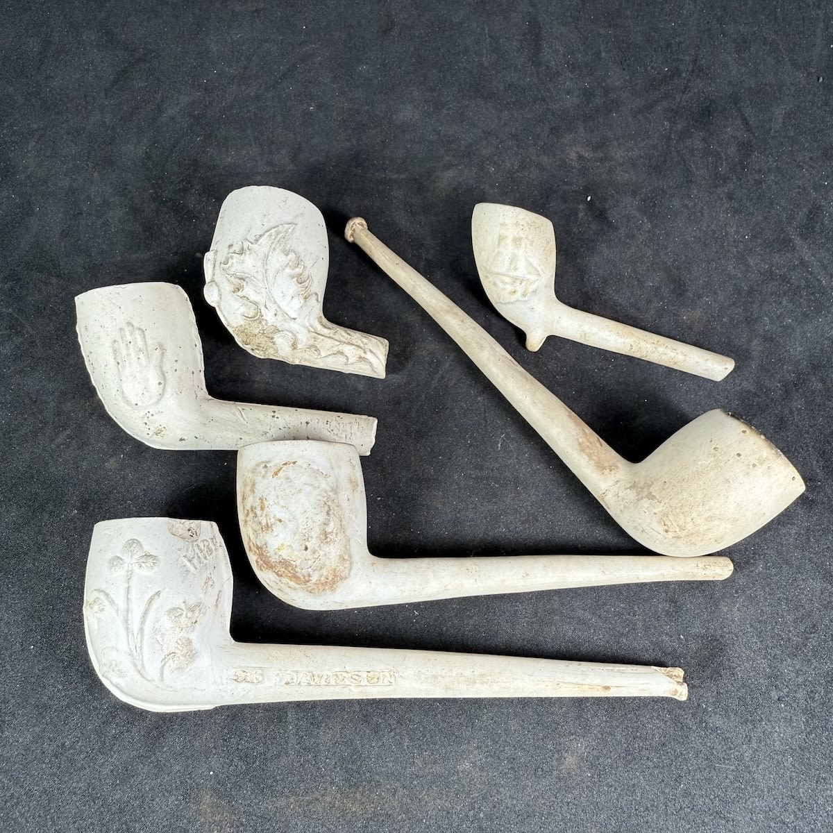 6 Clay Pipes: Complete Plain Complete Davidson Glasgow, Harp & Shamrocks Plain with most of stem Tiny one with Wheatsheaf & Ship Thistle & Hand Thistle.