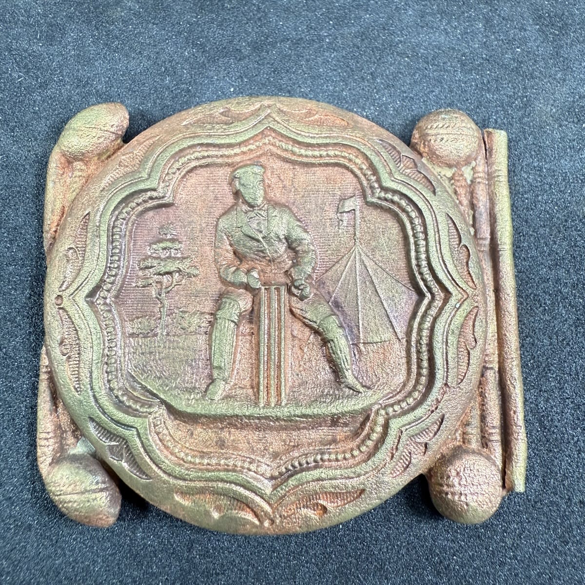 Cricket Belt Sash Buckle. Wicket Keeper at the Stumps. Tree & Tent in background.