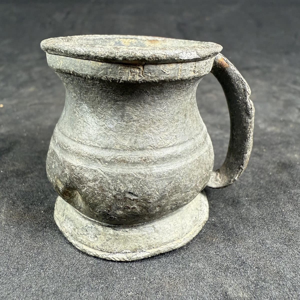 Small pewter measuring jug. Very early. Markings around the rim.