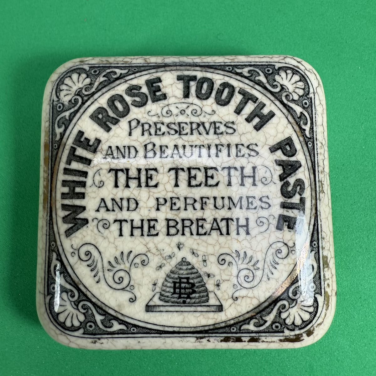 Pot Lid. Elliott Brothers White Rose Tooth Paste. Beehive with EB Monogram. Square lid. (Queensland & New South Wales)