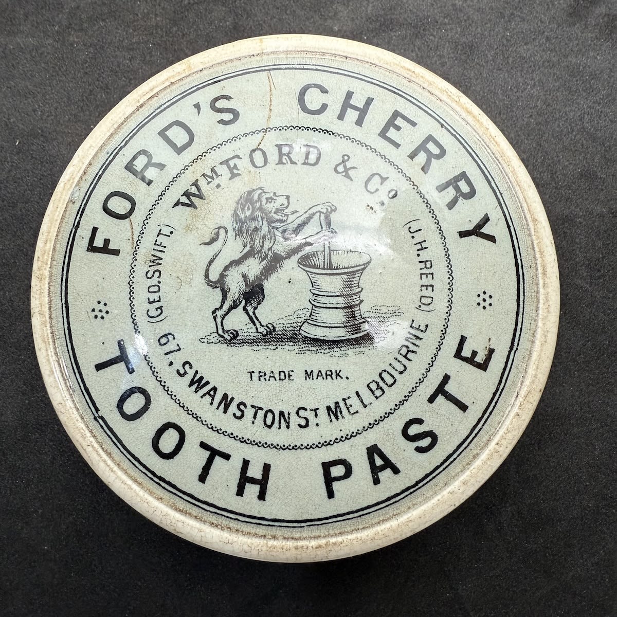 Pot Lid. Ford's Cherry Tooth Paste. Wm Ford & Co Swanston St Melbourne. Geo. Swift, J. H. Reed. Rampant Lion with Mortar & Pestle. Grey/Blue background. (Victoria)