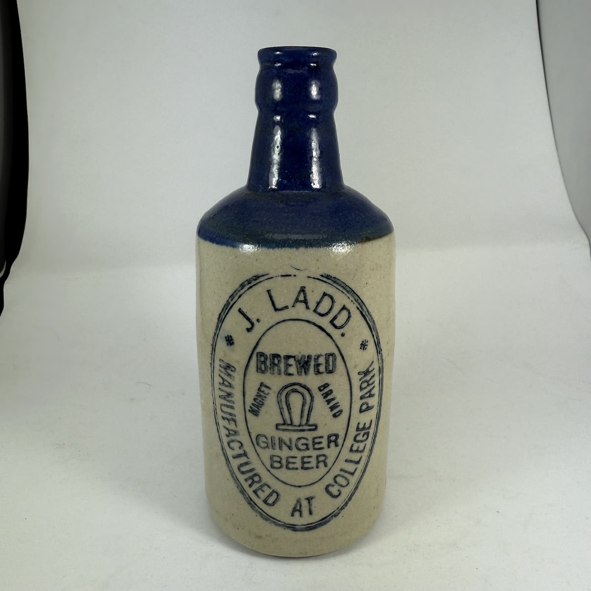 Ginger Beer. J. Ladd. Manufactured at College Park. Magnet Brand. Bendigo Pottery. Unusual dumpy type. Blue top. (South Australia)