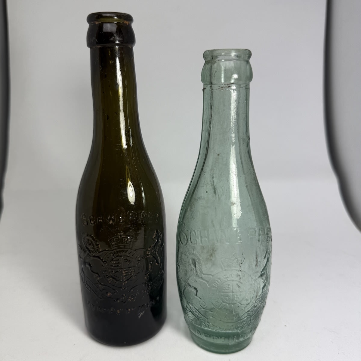 2 Schweppes Crown Seals: Dark Green/Black with spun top; Machine made skittle. Royal Coat of Arms on both. 6 oz.