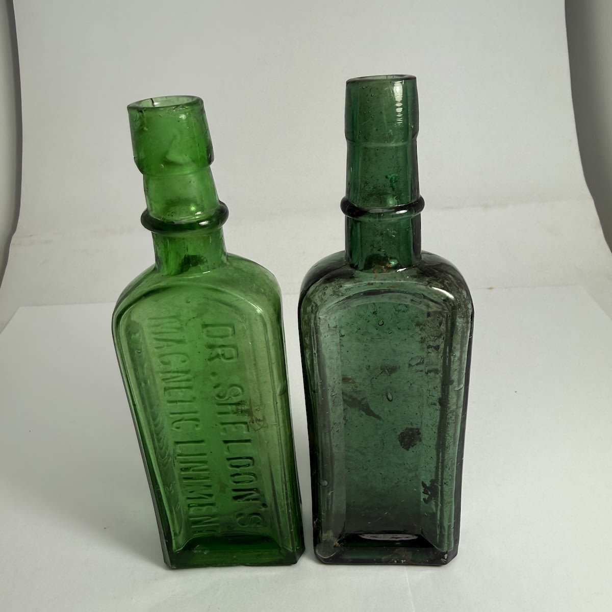 2 Cures: Dr. Sheldon's Magnetic Liniment, Cape Town & Boston; Dr Sheldon's shape but unembossed, L base mark for Leichhardt Glass Works.