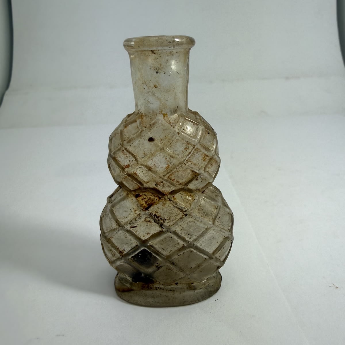 Perfume/Cologne. Two bulbous sections with wire like cross hatched pattern. Tool finished top. Clear. 1 oz.