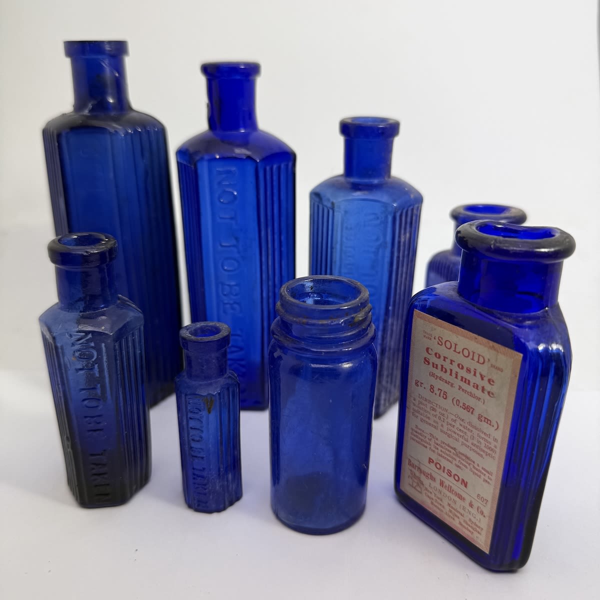 8 Cobalt Blue Bottles: Poison; Not to be taken; Made in Japan; Burroughs Wellcome. 1/2 - 4 oz. 58 - 140 mm