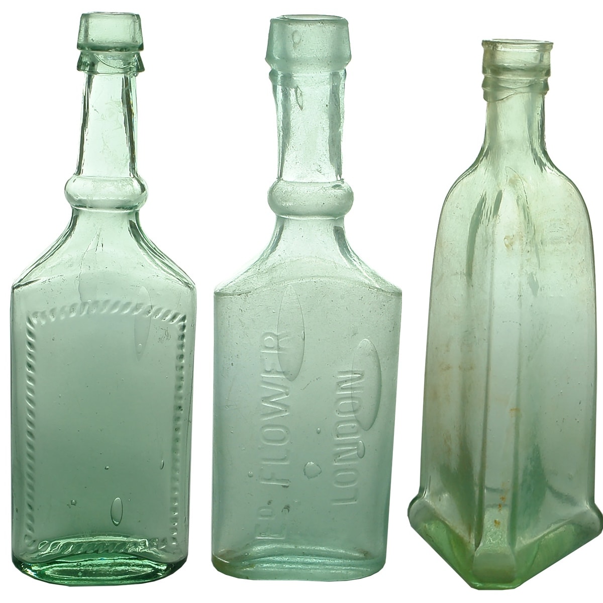 3 Goldfields era bottles: Larger Hair Oil with patterned label space; Ed Flower London small Hair Oil; Triangular sauce or oil with stepped base.