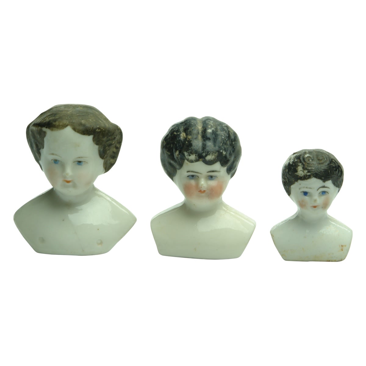 Dolls. Three size of ceramic dolls heads with black hair.
