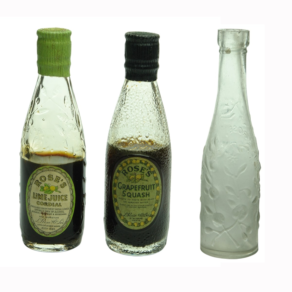Miniatures. 1. Labelled Rose's Lime Juice Cordial with contents, London & West Indies. Clear. 2. Labelled Rose's Grapefruit Squash with contents, St. Albans, Herts. Clear. 3. Early L. Rose & Co. Clear.