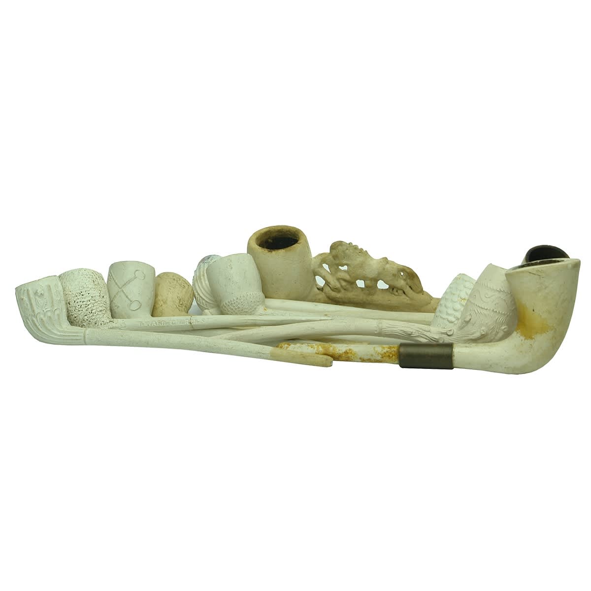 12 assorted clay pipes: Horse pushing decoration; Crossed Keys; T. Ward Chelsea; Trumpet like with copper repair; Various other patterns.
