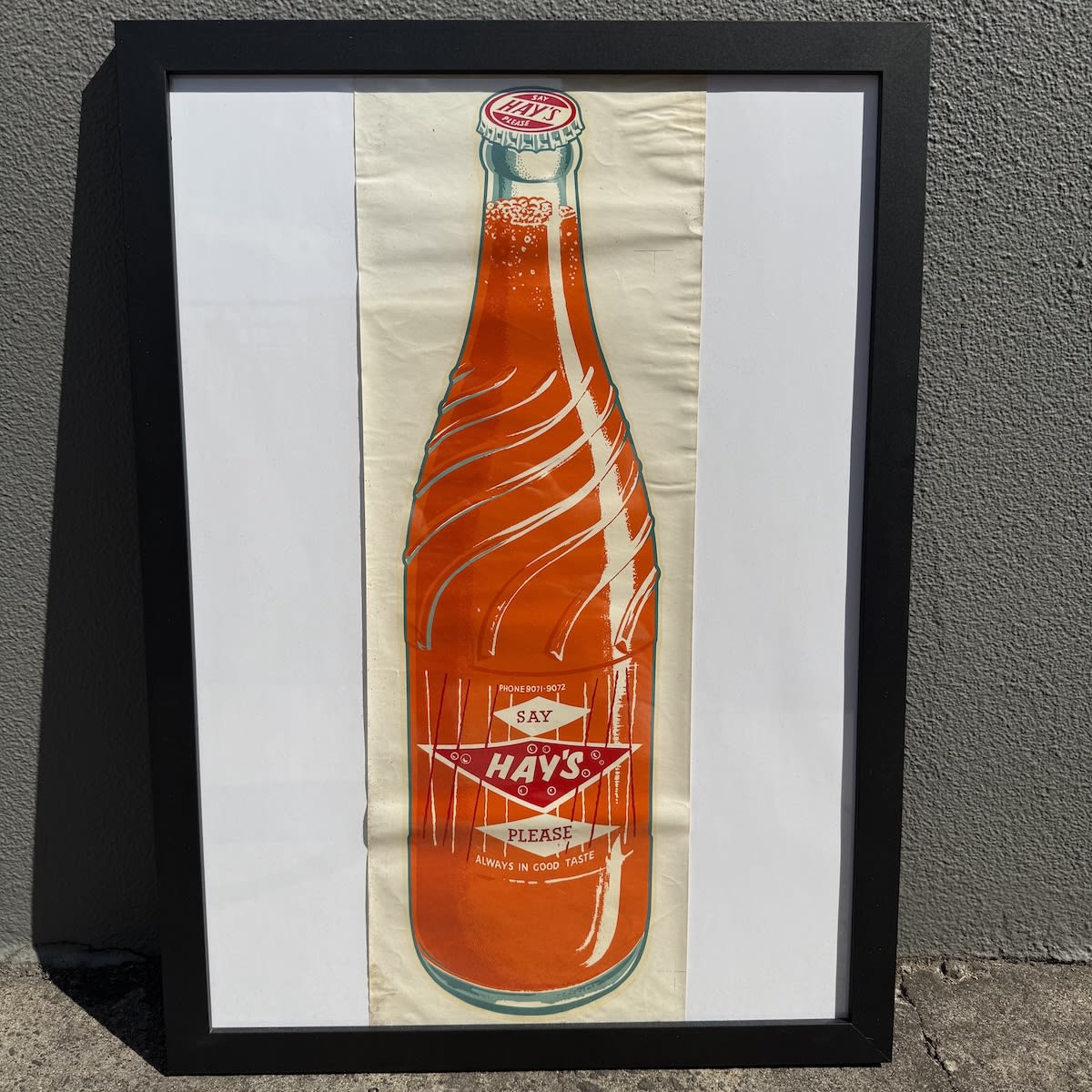 Window Advertising Decal. Say Hay's Please. Always in Good taste. Crown seal ceramic label bottle with orange liquid. Framed. Frame is 638 x 464 mm. (Colac, Victoria)