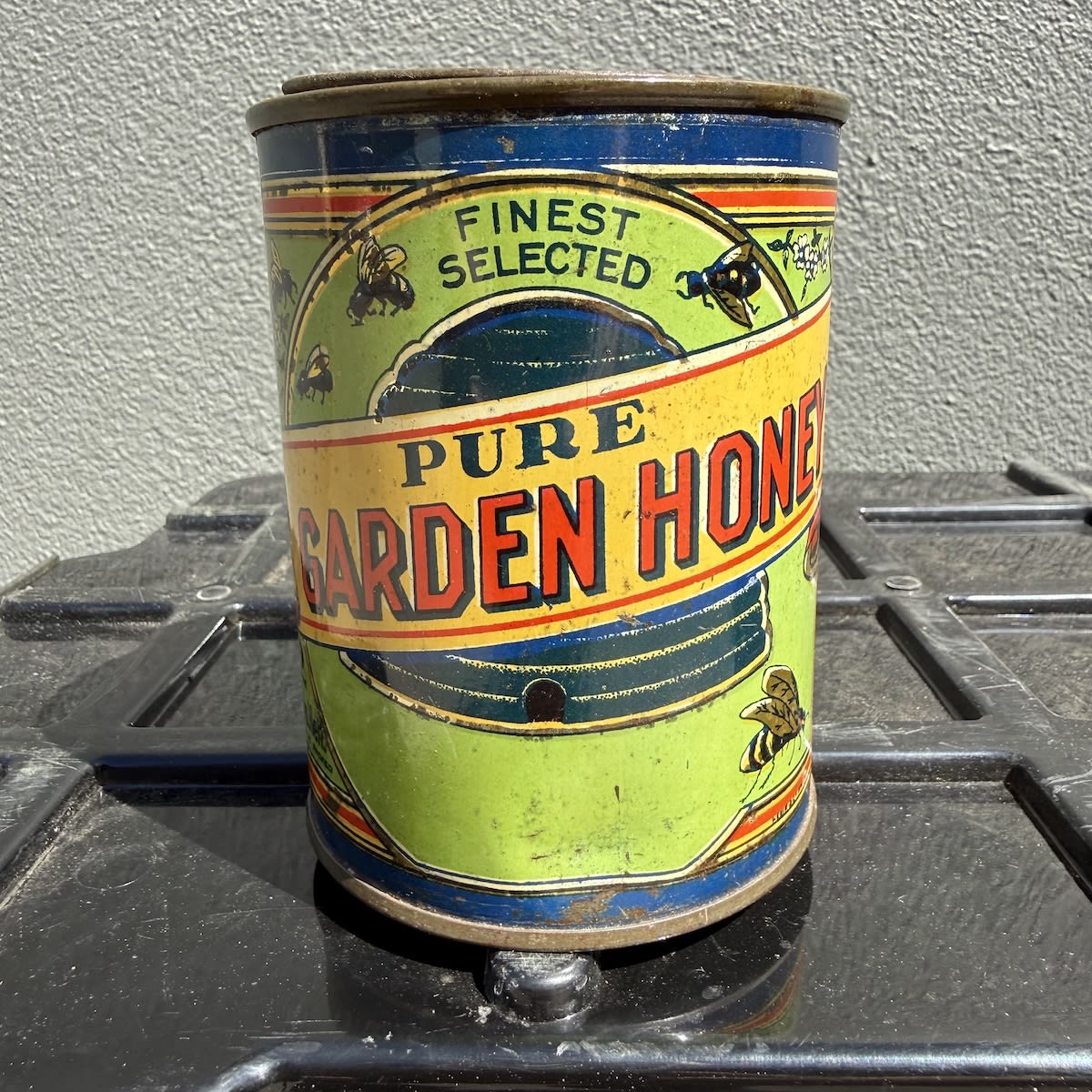 Small Tin. Pure Garden Honey. Multi-coloured. Bees. Crossed Australian Flags. Levin & Co in tiny print.