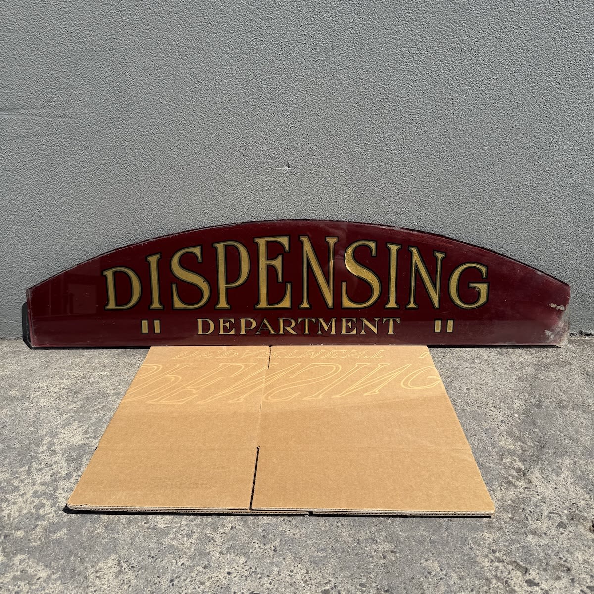 Large glass painted sign. Painted on the underside. Dispensing Department (Apparently from a Geelong store originally). Letters are gold with black border. Red background. (Too big for Australia Post. Other arrangements for collection or courier will have to be made by winning bidder)