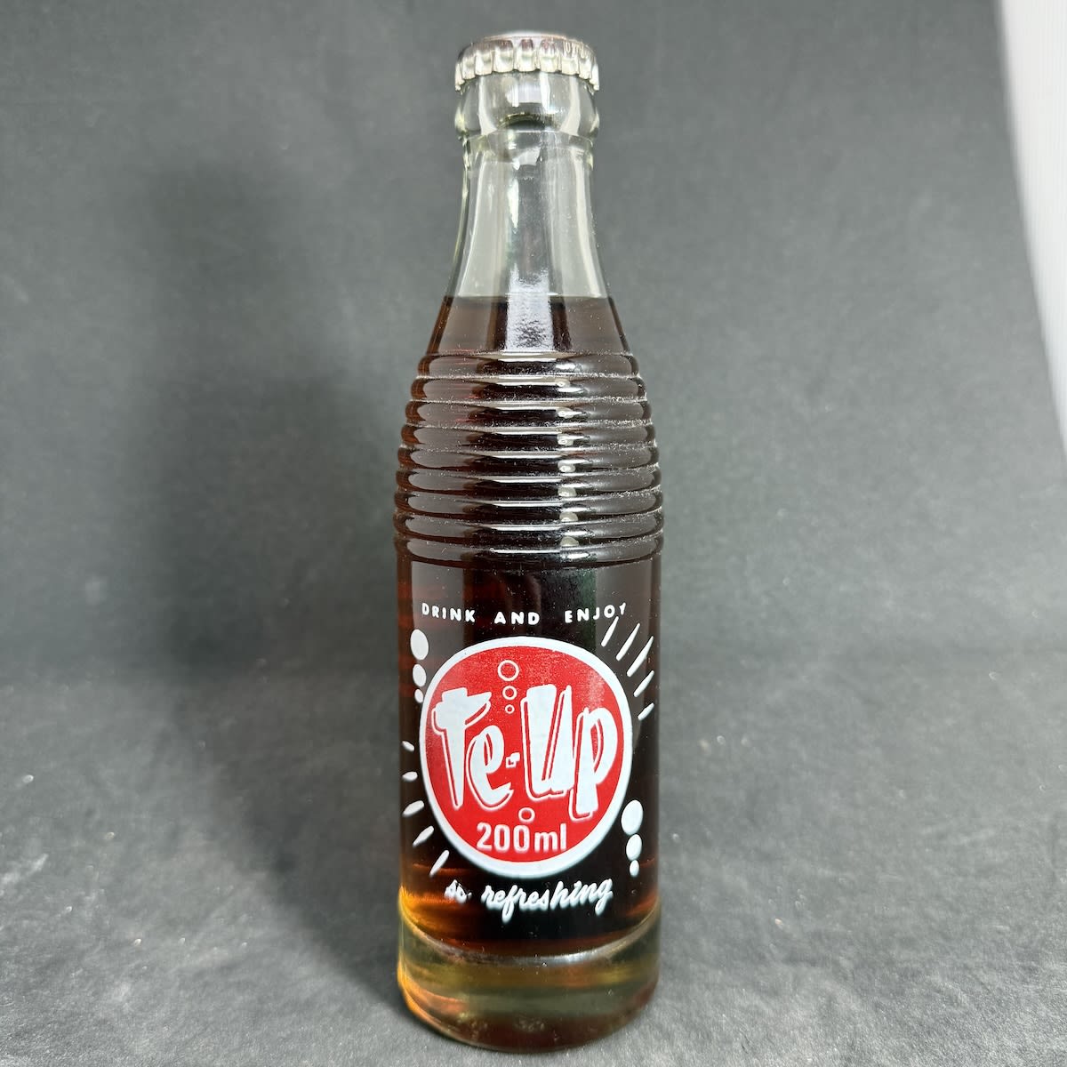 Ceramic Label Crown Seal. Te-Up Bottling Co. Pty. Ltd. Tas. Generic Cola Cap and Contents. 200 ml "Bullet" type shape bottle but without circles amongst the shoulder rings. (Tasmania)