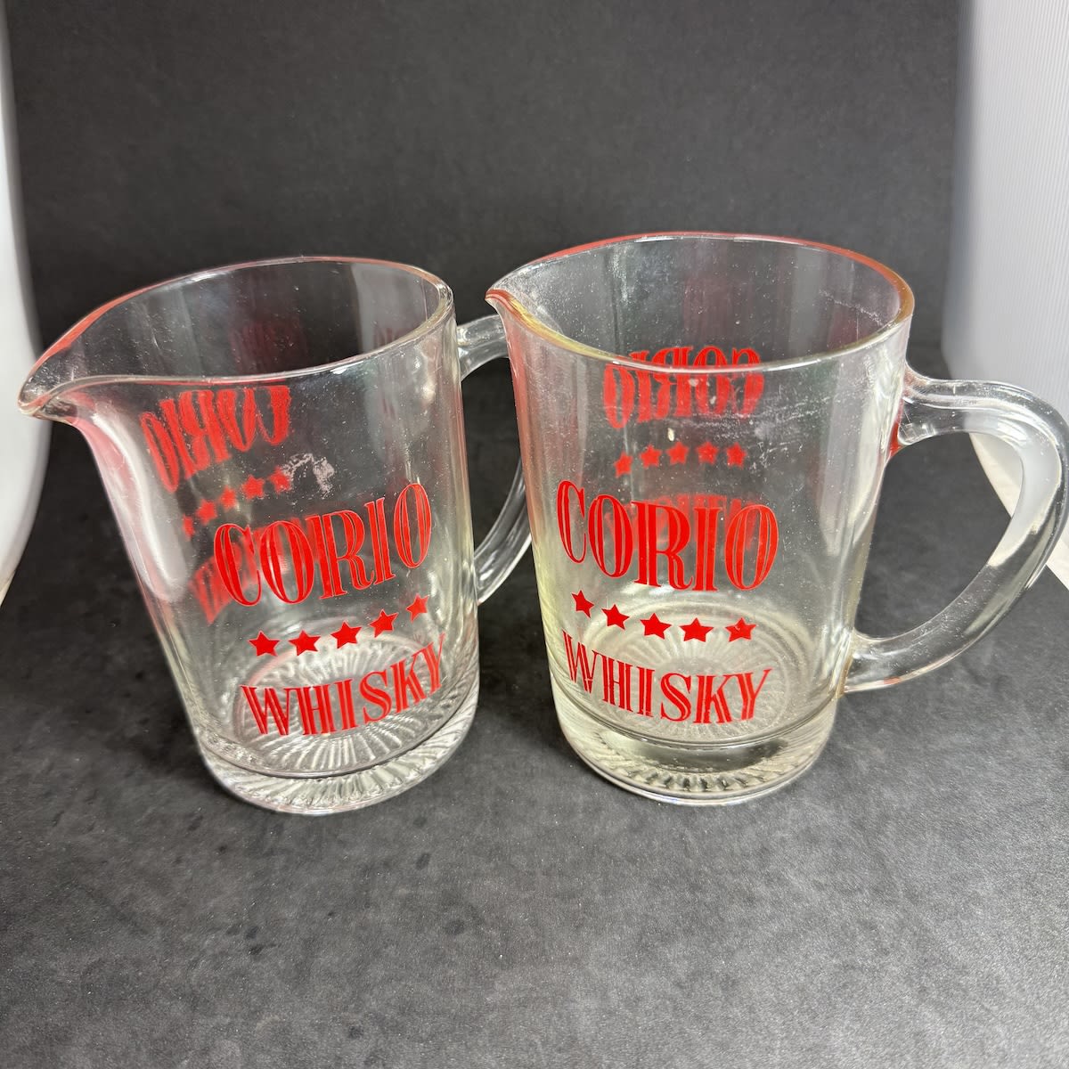 2 Whisky Water Jugs. Corio Five Star Whisky. Flower or starburst base. Red ceramic label print.
