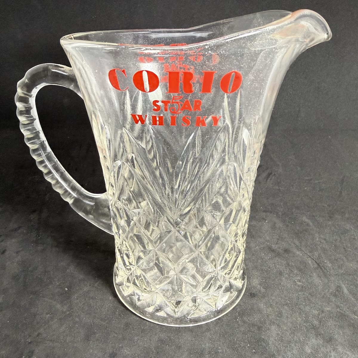 Whisky Water Jug. Corio 5 Star Whisky. Fancy moulded glass "vase" shape. Red Ceramic Label Print.